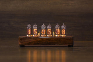 Six-tube Nixie clock in walnut showing hours, minutes and seconds, reflections on the desk