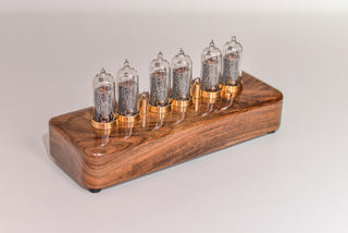 Walnut and brass six-tube Nixie clock seen from the side, rounded solid walnut case